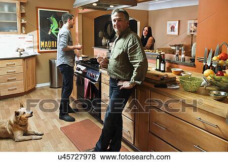 Stock Photo - Portrait of a mature man with family in contemporary kitchen, Albuquerque, New Mexico, USA. Fotosearch