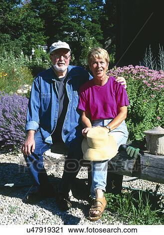 Portrait of mature couple sitting together on bench in garden View Large Photo Image Stock Image - Portrait of mature couple sitting together on bench in garden. Fotosearch
