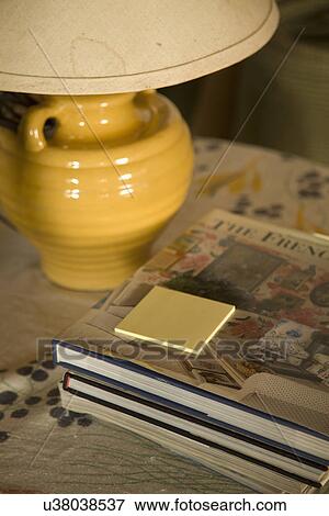 Stock Photo - Post it notes and books on stack beneath lamp; Carpinteria; California; USA. Fotosearch