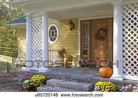 Pumpkins and flower pots at front door of single family home View Large Photo Image Stock Photo - Pumpkins and flower pots at front door of single family home. Fotosearch
