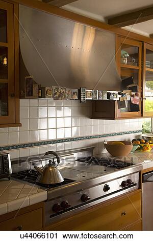 Stock Image - Range top and vent hood in traditional kitchen; Carpinteria; California; USA. Fotosearch