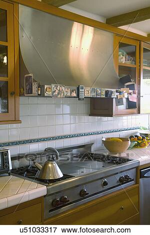 Stock Photo - Range top and vent hood in traditional kitchen; Carpinteria; California; USA. Fotosearch