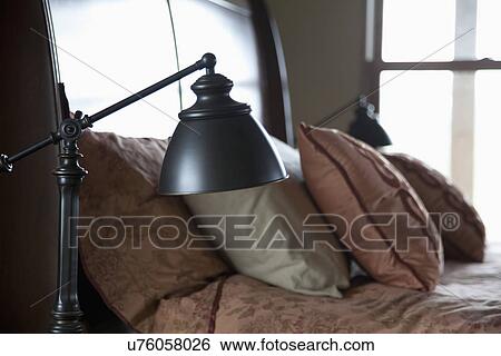 Stock Photograph - Reading lamp beside bed; Porterville; California; USA. Fotosearch