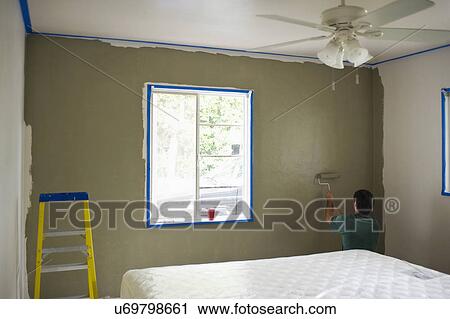 Rear view of man painting wall in bedroom View Large Photo Image Stock Image - Rear view of man painting wall in bedroom. Fotosearch