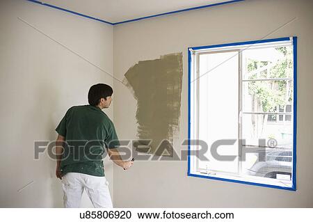 Rear view of man painting wall with roller View Large Photo Image Stock Image - Rear view of man painting wall with roller. Fotosearch