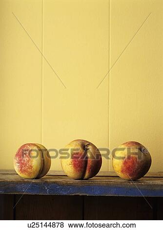 Stock Photo - Row of peaches on tabletop. Fotosearch