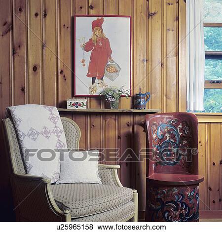 RUSTIC HOMES AND CABINS - Sitting area with upholstered chair with a hand carved and painted Kubbastool, (traditional Norwegian piece ) beside it, knotty pine walls, Carl Larsson style picture View Large Photo Image Stock Photo - RUSTIC HOMES AND CABINS - Sitting area with upholstered chair with a hand carved and painted Kubbastool, (traditional Norwegian piece ) beside it, knotty pine walls, Carl Larsson style picture. Fotosearch