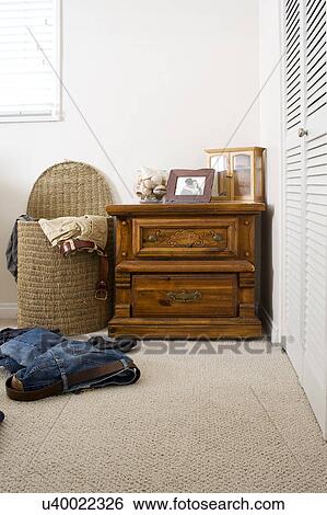 Stock Photograph - Scattered clothes by laundry basket in domestic room San Diego, California, United States of America. Fotosearch