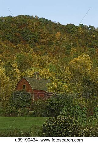 Picture - SEASONS - FALL: Red barn set in woods with trees turning into early fall colors. . Fotosearch