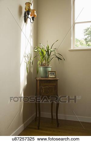 Stock Photography - Side table in corner with potted plant; Carpinteria; California; USA. Fotosearch