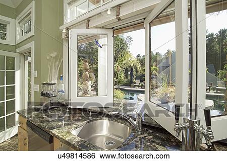 Sink on granite counter by open window in domestic kitchen View Large Photo Image Stock Photograph - Sink on granite counter by open window in domestic kitchen. Fotosearch