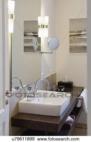 Stock Photo - Sink on wooden countertop in domestic bathroom. Fotosearch