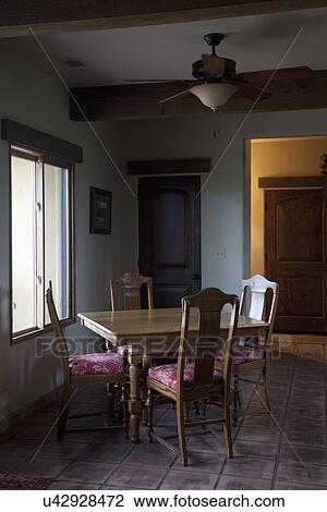 Stock Image - Small wooden dining room table near window; Porterville; California; USA. Fotosearch