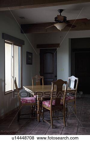 Stock Photo - Small wooden dining room table near window; Porterville; California; USA. Fotosearch