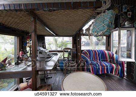 Stock Photo - Sofa covered with colorful throw blanket in cottage. Fotosearch