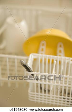 Stock Image - Spoon in dish drying rack. Fotosearch