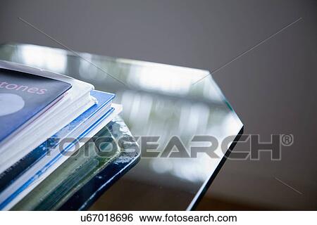 Stock Photograph - Stack of books on glass coffee table; Carpinteria; California; USA. Fotosearch