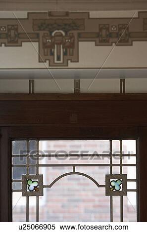 Stock Photography - STAINED GLASS: Detail of stained and leaded glass window, with stylized wallpaper border above window, Arts and Crafts home. Fotosearch