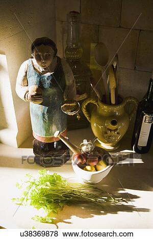 Stock Photo - Statue and cooking supplies on kitchen counter; Ladera Ranch; California; USA. Fotosearch