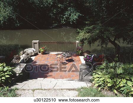 Stock Image - Stone path leading to patio by river. Fotosearch