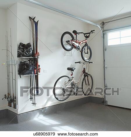 Stock Photo - STORAGE: garage storage of sporting equipment, two bikes, ski boots and skis, fishing gear. Fotosearch