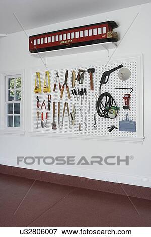 Storage: Inside garage, new construction,. Close up of white wall with various garden and hand tools on peg board, vertical View Large Photo Image Stock Photo - Storage: Inside garage, new construction,. Close up of white wall with various garden and hand tools on peg board, vertical. Fotosearch