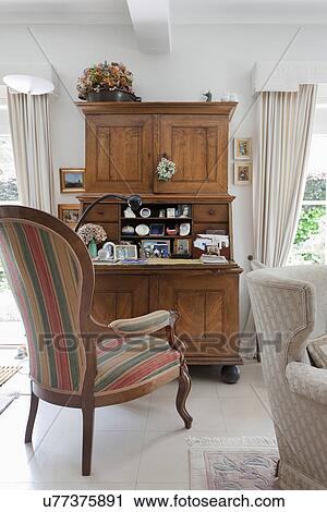Striped armchair at wooden desk in traditional living room View Large Photo Image Stock Image - Striped armchair at wooden desk in traditional living room. Fotosearch