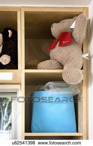 Stock Photo - Stuffed bear in wooden cubby. Fotosearch