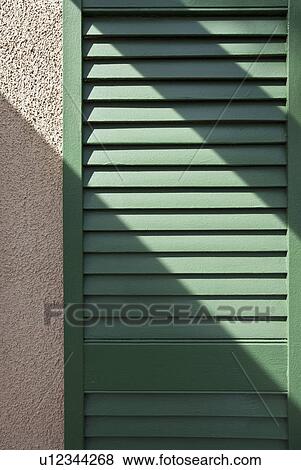 Stock Photo - Sunlight over green shutter. Fotosearch