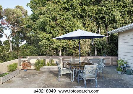 Sunshade with table and chairs on patio View Large Photo Image Stock Photo - Sunshade with table and chairs on patio. Fotosearch