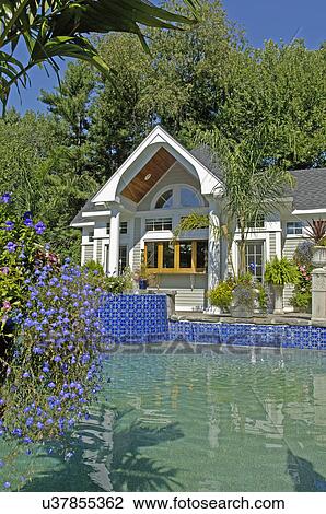 Stock Image - Swimming pool in front of pool house. Fotosearch