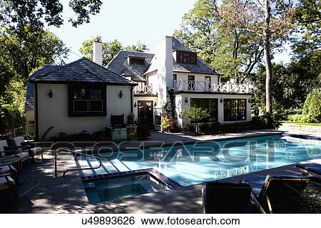 SWIMMING POOLS: looking over pool to French Normandy style house, white brick, balcony, hot tub to left within pool space View Large Photo Image Stock Photograph - SWIMMING POOLS: looking over pool to French Normandy style house, white brick, balcony, hot tub to left within pool space. Fotosearch