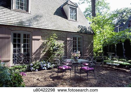 Table and chairs in back yard of residential house View Large Photo Image Stock Photo - Table and chairs in back yard of residential house. Fotosearch