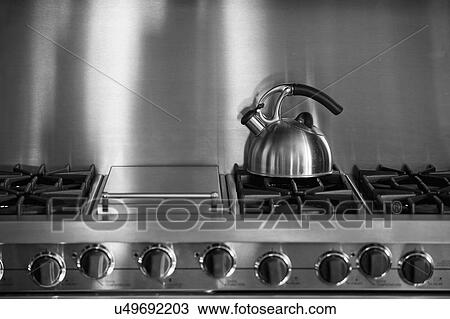 Stock Image - Tea Kettle on stainless steel oven; Irvine; California; USA. Fotosearch