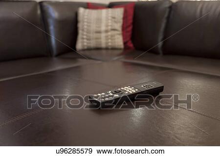 Stock Photo - Television remote on leather sofa; Burbank; California; USA. Fotosearch