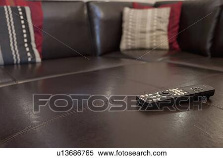 Stock Photography - Television remote on leather sofa; Burbank; California; USA. Fotosearch