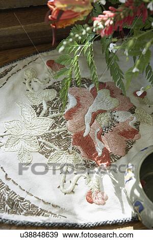 Stock Photo - TEXTILES: Arts and Crafts embroidered linen, poppy flowers, real flowers overhead. Fotosearch