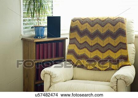 Throw blanket on armchair by window View Large Photo Image Picture - Throw blanket on armchair by window. Fotosearch