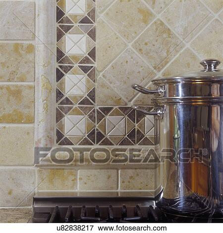 TILE - Detail of tumbled marble tile behind commercial kitchen range. Beige and tan colors. Stainless steel pot on stove top. View Large Photo Image Stock Photo - TILE - Detail of tumbled marble tile behind commercial kitchen range. Beige and tan colors. Stainless steel pot on stove top.. Fotosearch