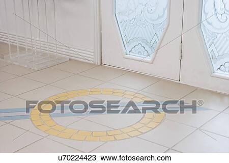 Stock Image - TILE FLOOR DETAIL: Art Deco design in tile, pale yellow and blue, part of lucite table, bottom of glass front doors. Fotosearch