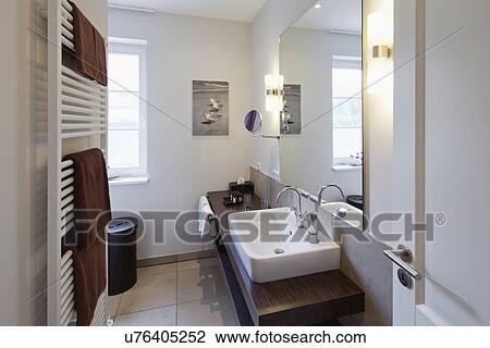 Stock Image - Towel warmer and sink in domestic bathroom. Fotosearch