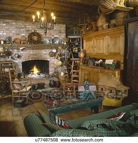 Toy house on coffee table with candle lit chandelier in rustic living room View Large Photo Image Stock Photo - Toy house on coffee table with candle lit chandelier in rustic living room. Fotosearch