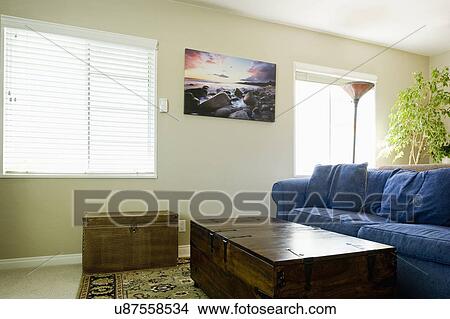 Picture - Treasure chest and blue sofas in living room. Fotosearch