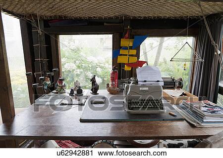 Stock Image - Typewriter with stack of books on wooden table in cottage. Fotosearch