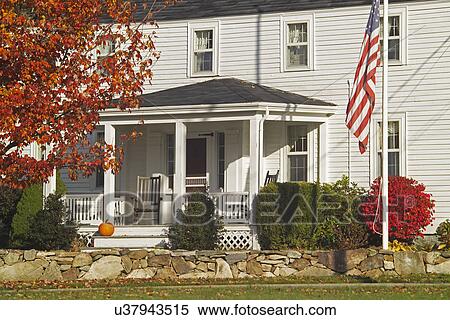 Stock Photography - USA flag in front of single family home. Fotosearch