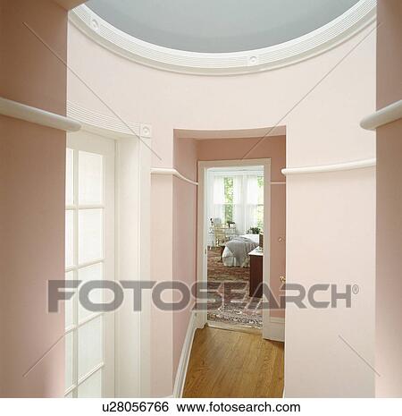 Stock Photograph - Vestibule with pink walls leading to bedroom in traditional house. Fotosearch
