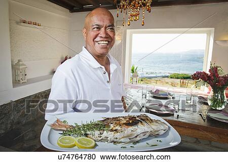 Waiter holding platter of fish, Mykonos, Greece View Large Photo Image Stock Image - Waiter holding platter of fish, Mykonos, Greece. Fotosearch