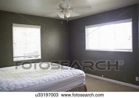 White Bed And Ceiling Fan In Freshly Painted Bedroom Stock Image