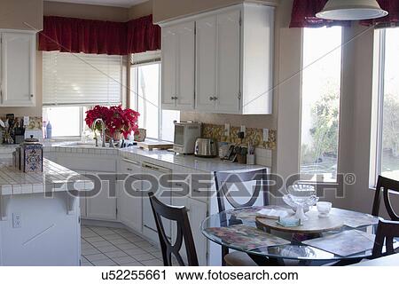 Stock Image - White monochromatic traditional kitchen with island, Laguna Beach, California, USA. Fotosearch