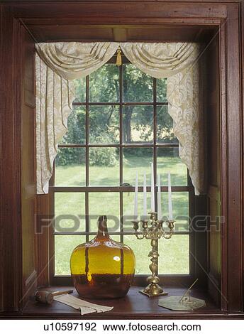 WINDOW TREATMENTS: Daniel Boone home. Hand-blown colored glass jug and brass candelabra sit in window sill, double hung window, floral pattern swag and jabots, colonial, molding View Large Photo Image Stock Image - WINDOW TREATMENTS: Daniel Boone home. Hand-blown colored glass jug and brass candelabra sit in window sill, double hung window, floral pattern swag and jabots, colonial, molding. Fotosearch